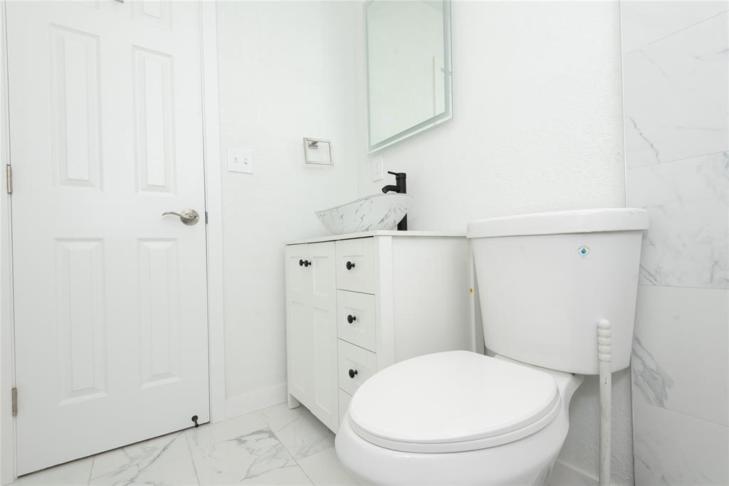713 Southwest 4th Court Hallandale Beach, FL 33009 - Photo 17 of 38 a white toilet sitting next to a bathroom sink
