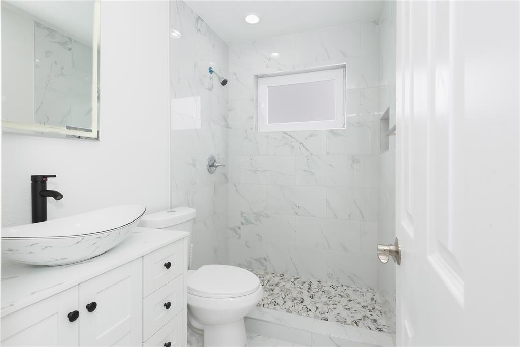 713 Southwest 4th Court Hallandale Beach, FL 33009 - Photo 18 of 38 a bathroom with a sink a toilet and shower