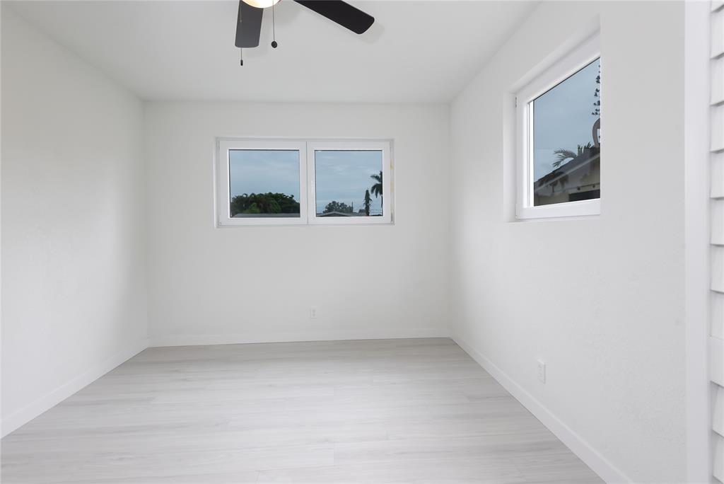 713 Southwest 4th Court Hallandale Beach, FL 33009 - Photo 20 of 38 an empty room with a ceiling fan and window