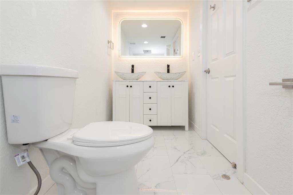 713 Southwest 4th Court Hallandale Beach, FL 33009 - Photo 21 of 38 a bathroom with a sink a toilet and mirror