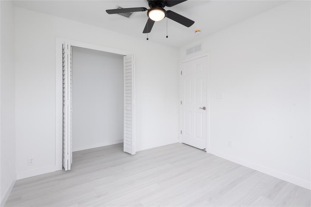 713 Southwest 4th Court Hallandale Beach, FL 33009 - Photo 22 of 38 an empty room with a ceiling fan and carpet
