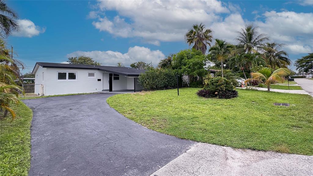 713 Southwest 4th Court Hallandale Beach, FL 33009 - Photo 9 of 38 a front view of a house with a yard