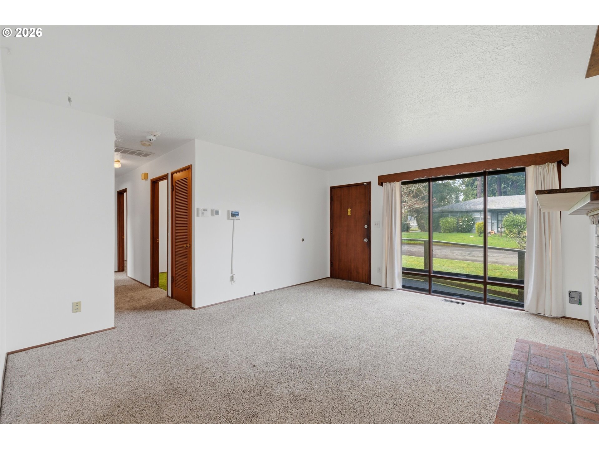 16706 Southeast Ankeny Street Portland, OR 97233 - Photo 5 of 43 a view of an empty room with a window and a kitchen