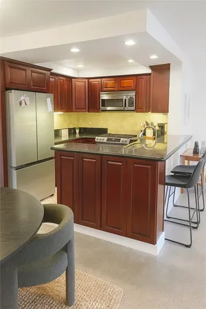 a kitchen with stainless steel appliances granite countertop a sink and a refrigerator