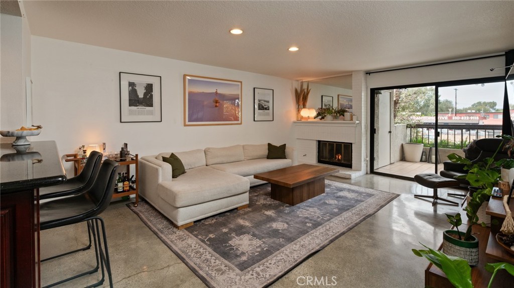 8512 Tuscany Avenue, Unit 222 Playa del Rey, CA 90293 - Photo 3 of 24 a living room with furniture a rug and a large window