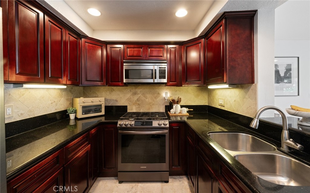 8512 Tuscany Avenue, Unit 222 Playa del Rey, CA 90293 - Photo 4 of 24 a kitchen with a sink stove and microwave