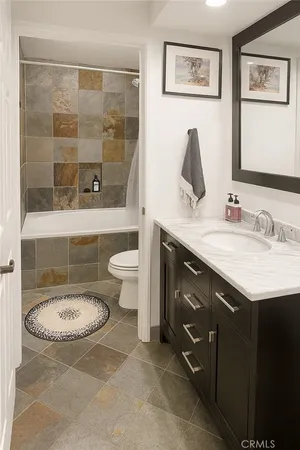 a bathroom with a granite countertop sink toilet and shower