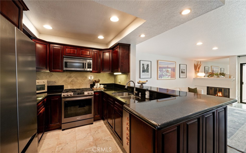 8512 Tuscany Avenue, Unit 222 Playa del Rey, CA 90293 - Photo 6 of 24 a kitchen with stainless steel appliances granite countertop a stove a sink a microwave and a refrigerator