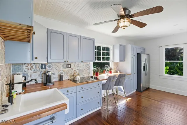 a kitchen with stainless steel appliances kitchen island granite countertop a refrigerator a sink a stove and cabinets