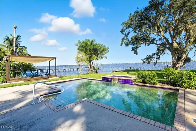 a view of swimming pool with lounge chair and trees in the background