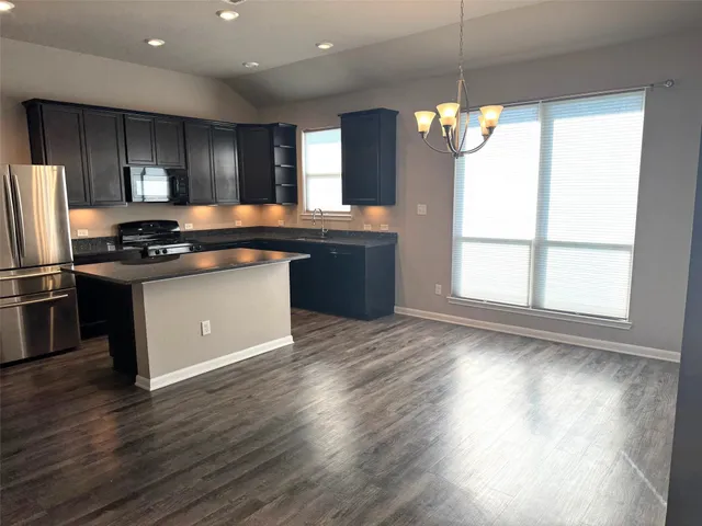 a kitchen with stainless steel appliances granite countertop a stove a sink a refrigerator and a oven