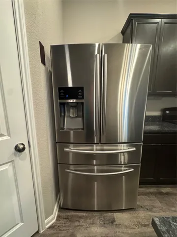 a view of a refrigerator and wooden floor