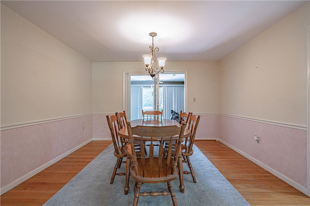 4815 Mill Road Schnecksville, PA 18078 - Photo 11 of 48 A classic chandelier illuminates the dining area, featuring hardwood flooring and a bright open doorway.