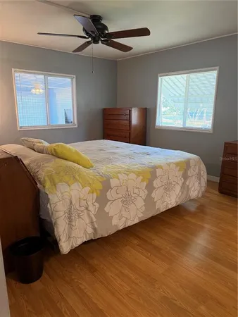 a bedroom with a bed and wooden floor