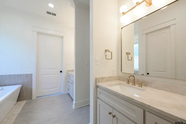 a bathroom with a granite countertop sink and a mirror