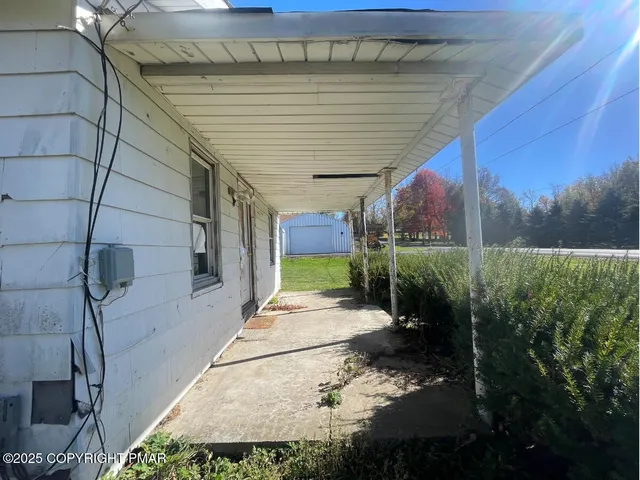 a view of a chair and table in the back yard of the house