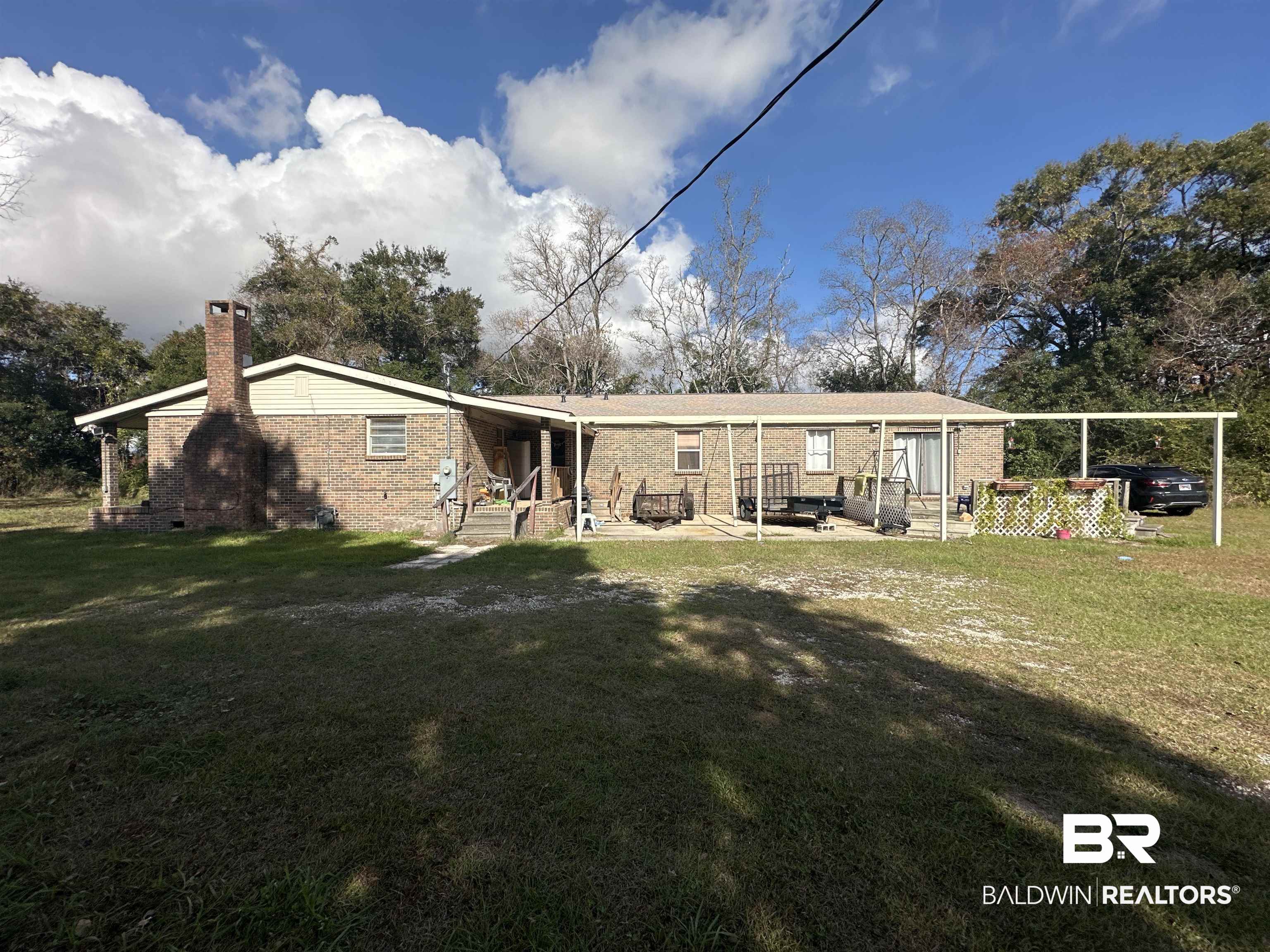 9520 C Four Mile Road Irvington, AL 36544 - Photo 27 of 32 Rear view of property featuring a carport and a yard