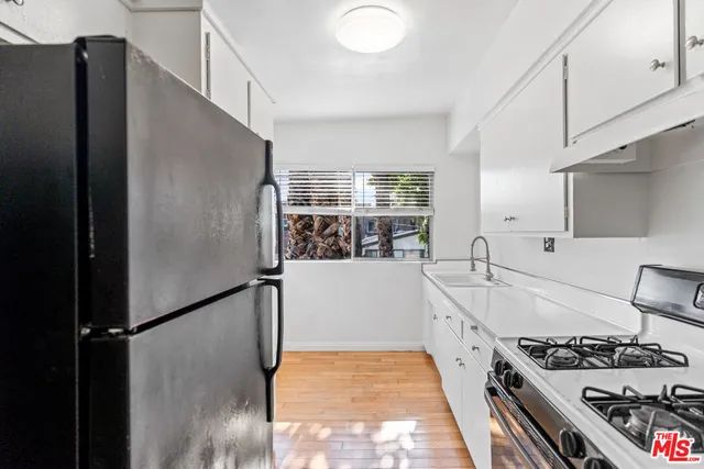 a kitchen with stainless steel appliances granite countertop a refrigerator and a stove