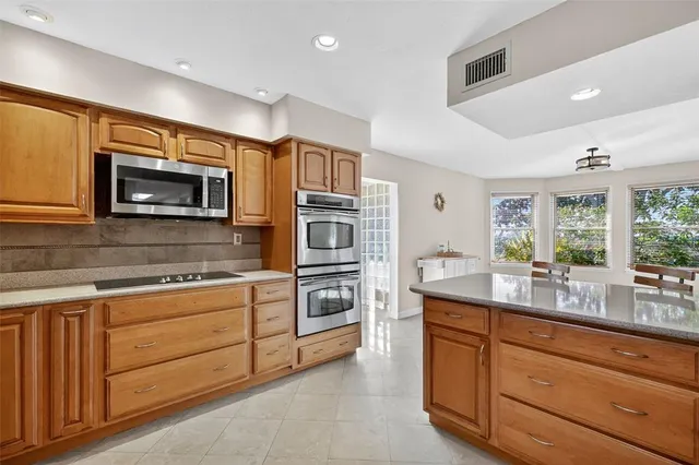 a kitchen with stainless steel appliances granite countertop a stove and cabinets