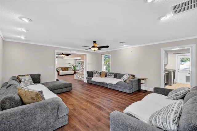 a living room with furniture and a wooden floor