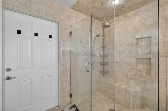 a view of an empty room with chandelier fan and a window