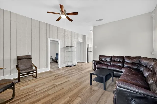 an aerial view of a residential houses with outdoor space and trees