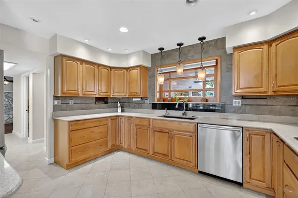a kitchen with granite countertop white cabinets sink and stainless steel appliances