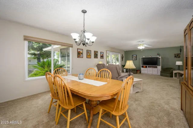 a view of a dining room and a livingroom with furniture wooden floor a chandelier