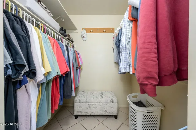 a view of walk in closet with clothes and shoes