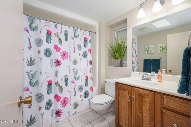 a bathroom with a sink a toilet and shower curtain