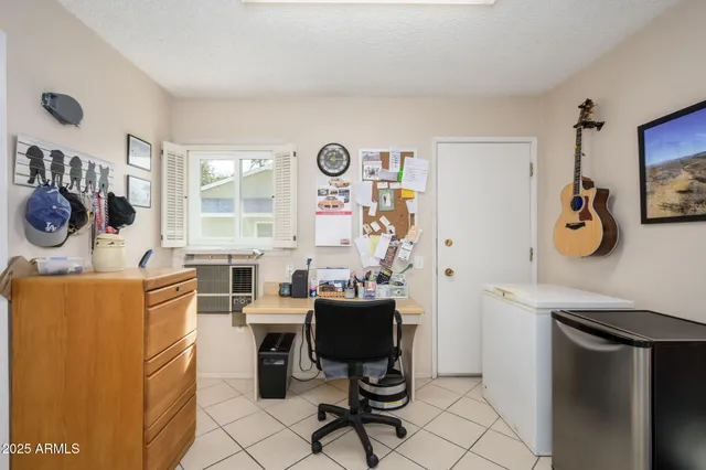 a view of a workspace with furniture and a window