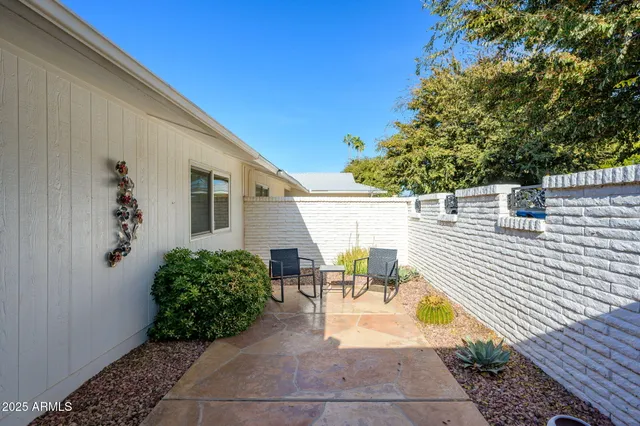 a view of a patio with couches table and chairs and potted plants