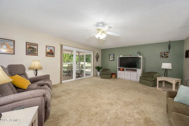 a living room with furniture a flat screen tv and a window