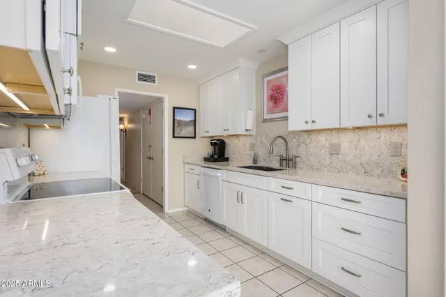 a kitchen with granite countertop a sink stainless steel appliances and cabinets