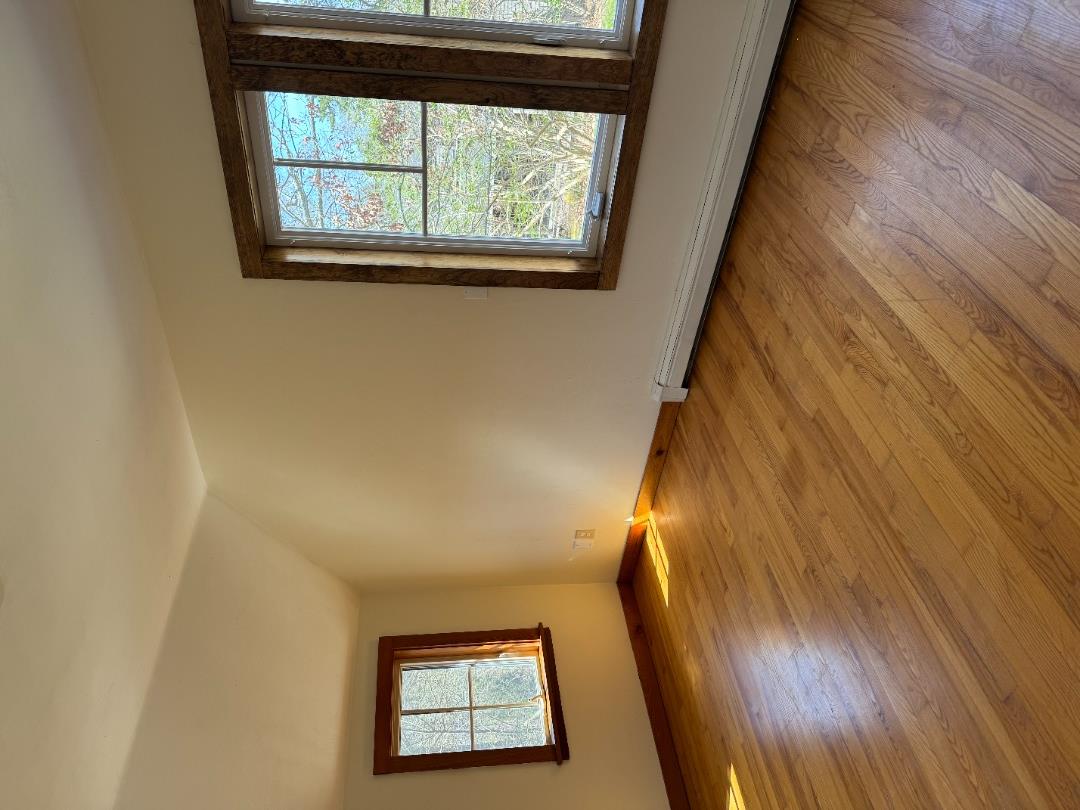 4 Rock Pond Road West Tisbury, MA 02568 - Photo 18 of 37 a view of an empty room with wooden floor and a window
