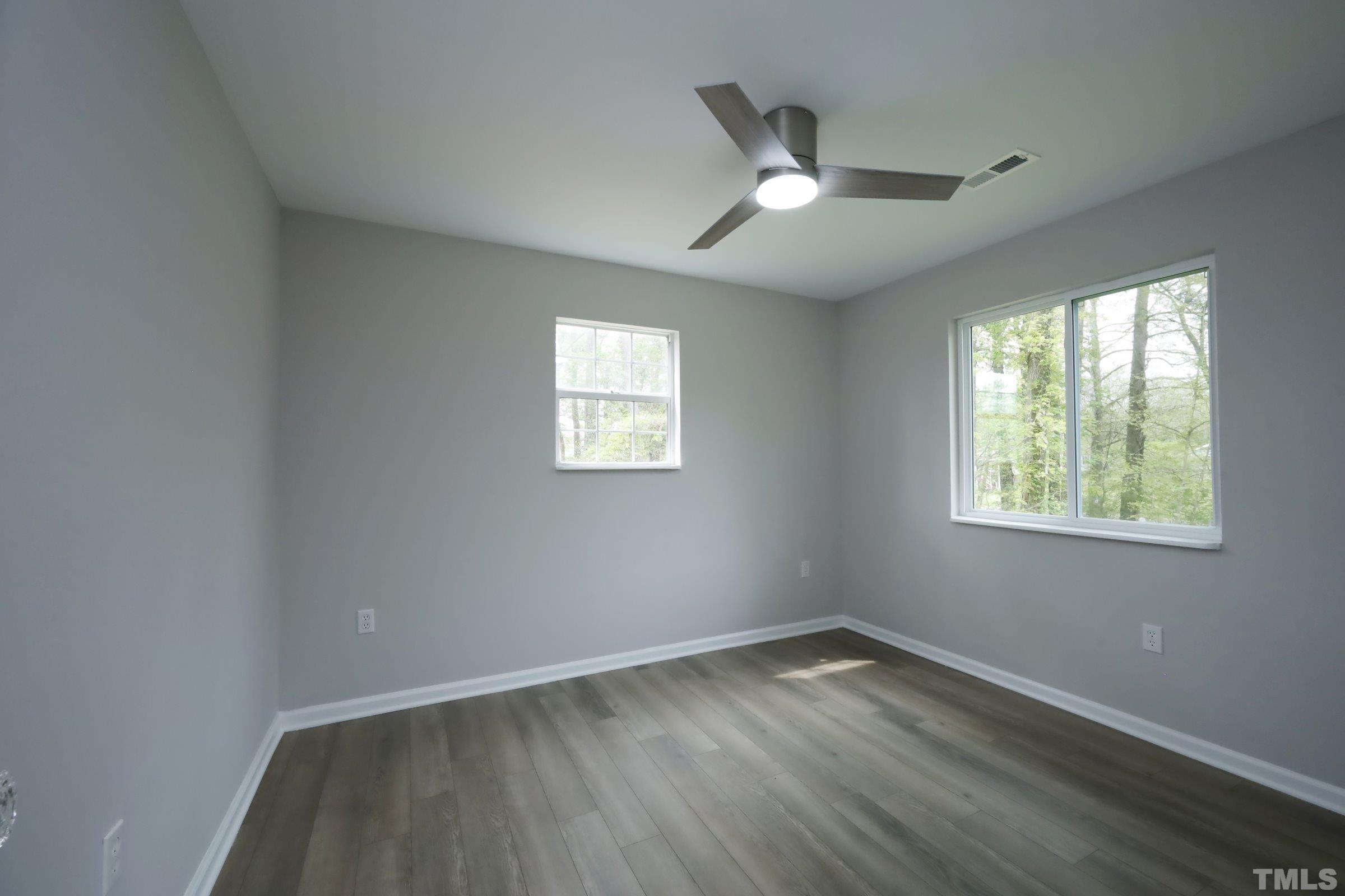 100 Mitchener Street Garner, NC 27529 - Photo 17 of 37 an empty room with wooden floor fan and windows