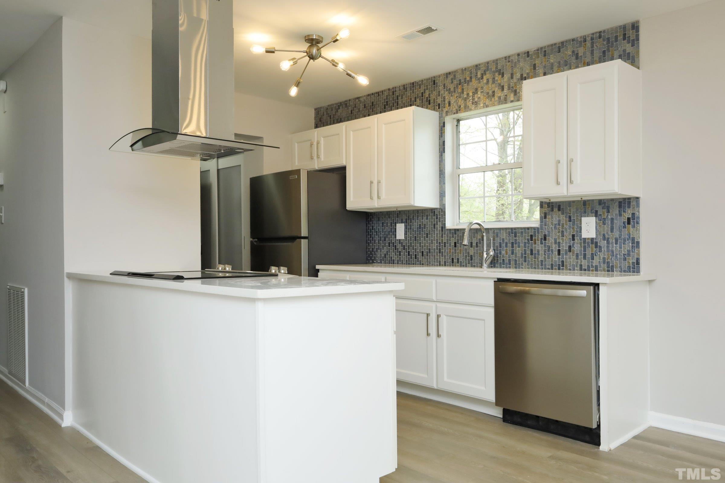 100 Mitchener Street Garner, NC 27529 - Photo 6 of 37 a kitchen with kitchen island granite countertop a sink cabinets and wooden floor