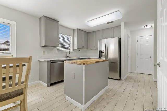 a kitchen with a refrigerator sink and cabinets