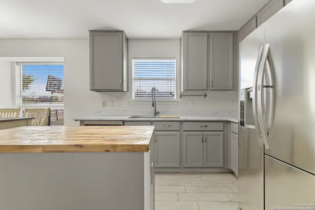 a kitchen with stainless steel appliances granite countertop a sink and a refrigerator