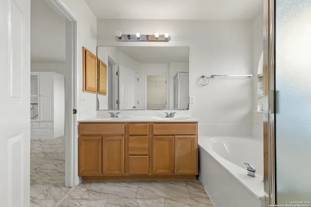 a bathroom with a tub a sink and mirror