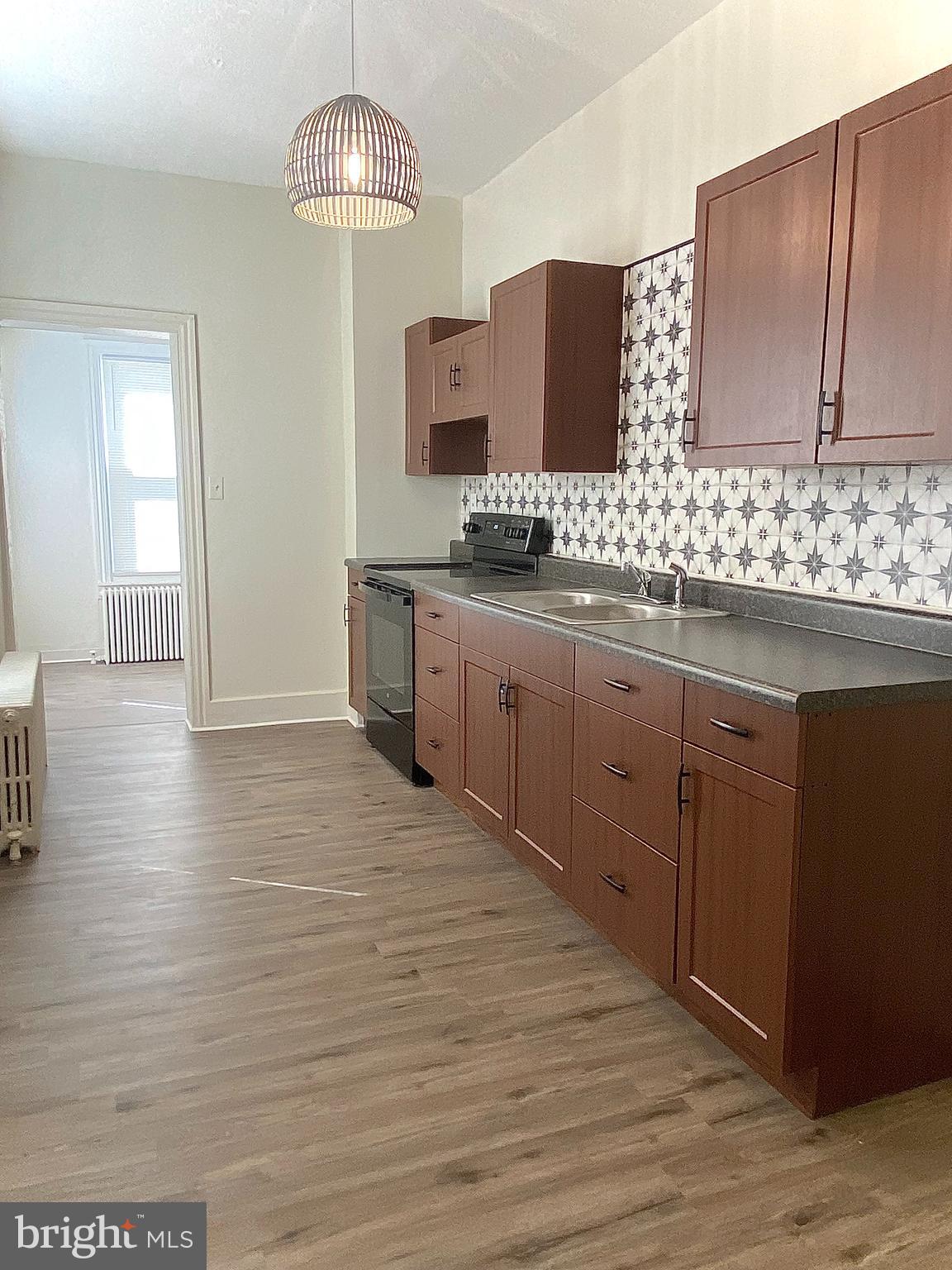 424 Locust Street Reading, PA 19604 - Photo 3 of 17 a large kitchen with granite countertop a stove and cabinets