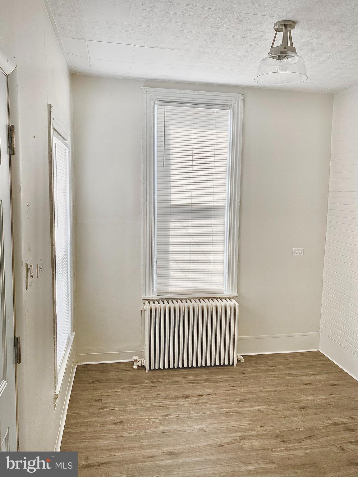 424 Locust Street Reading, PA 19604 - Photo 7 of 17 an empty room with wooden floor and windows