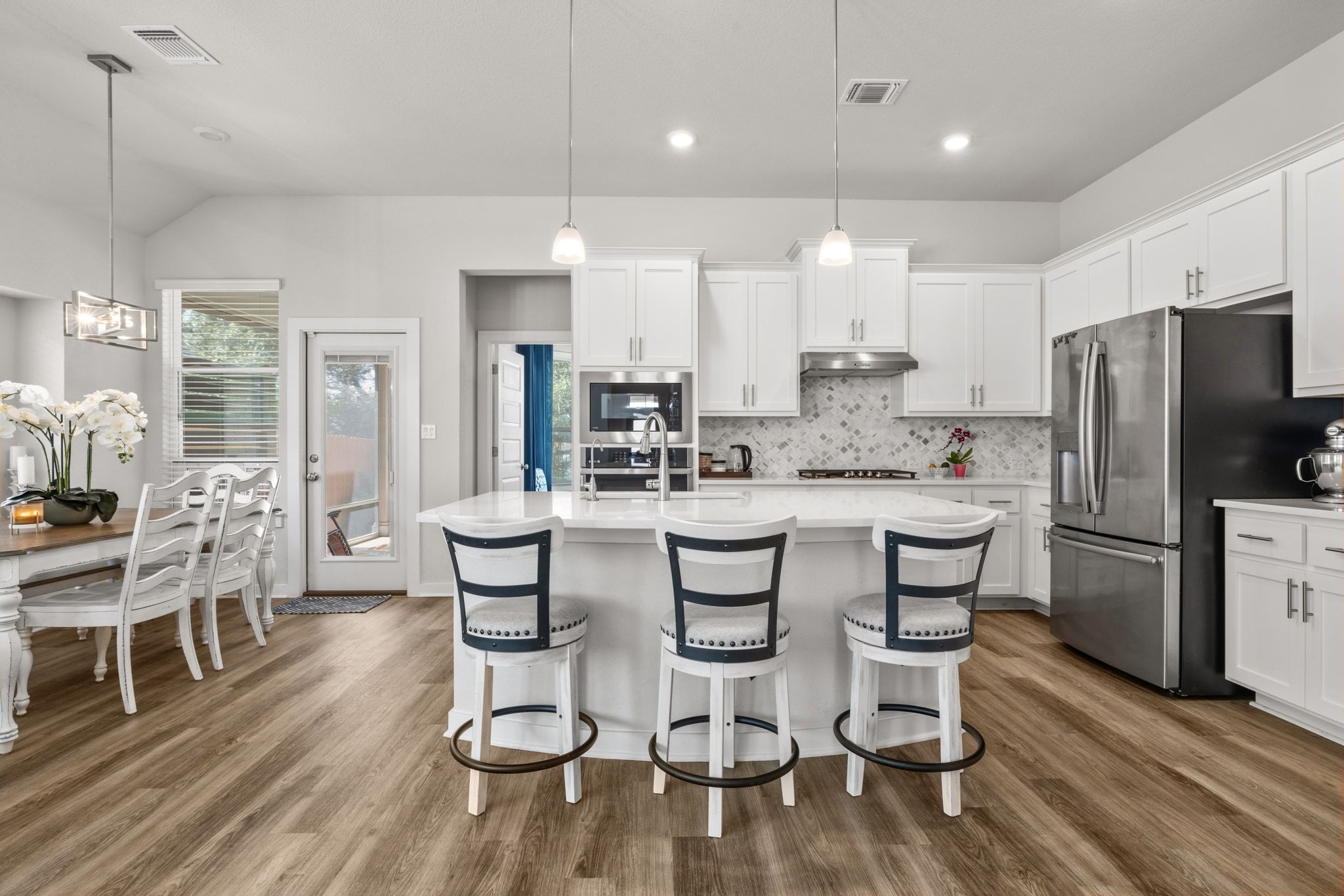 1006 Summer Glen Georgetown, TX 78628 - Photo 15 of 40 The kitchen features an open layout with quartz countertops, a tile backsplash, and shaker-style cabinetry