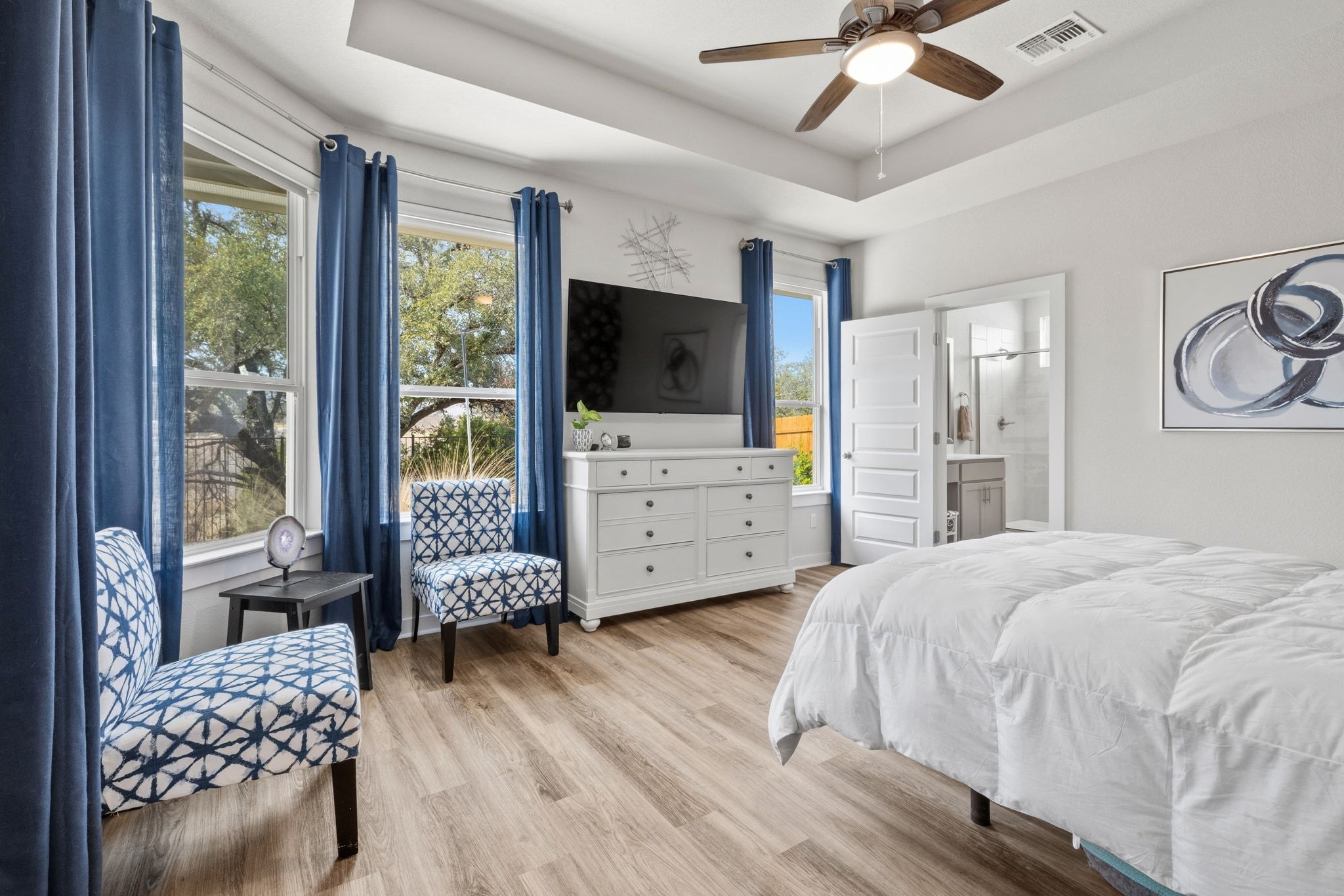 1006 Summer Glen Georgetown, TX 78628 - Photo 4 of 40 Remote-controlled blinds and vinyl plank flooring throughout the primary bedroom maintain a clean and consistent look