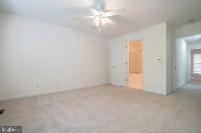 an empty room with a ceiling fan and a window
