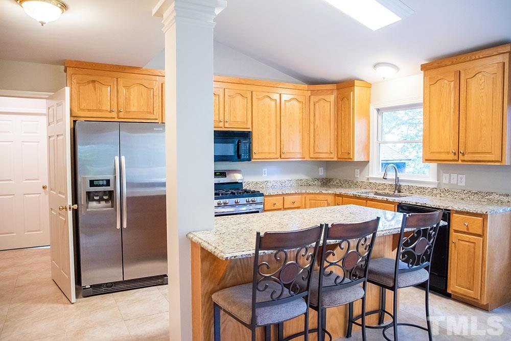 150 Shannon Road Timberlake, NC 27583 - Photo 11 of 30 a kitchen with stainless steel appliances granite countertop a stove a refrigerator and a chair
