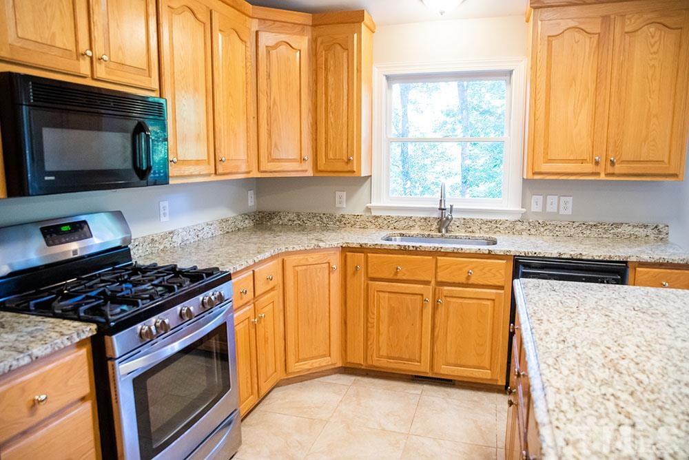 150 Shannon Road Timberlake, NC 27583 - Photo 12 of 30 a kitchen with granite countertop cabinets stainless steel appliances a sink and a window