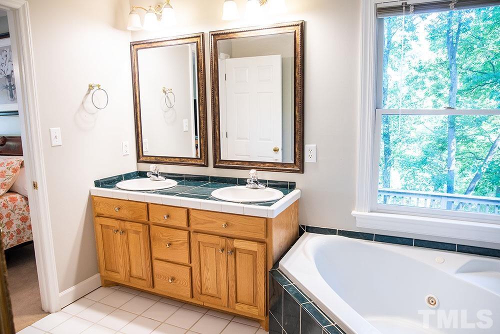 150 Shannon Road Timberlake, NC 27583 - Photo 18 of 30 a bathroom with a tub sink and mirror