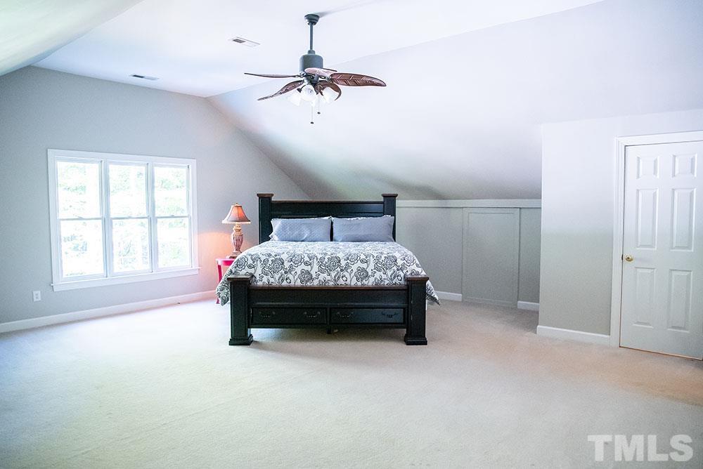 150 Shannon Road Timberlake, NC 27583 - Photo 21 of 30 a bedroom with a bed and a chandelier