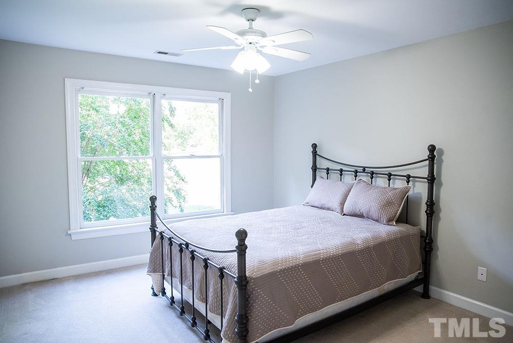 150 Shannon Road Timberlake, NC 27583 - Photo 22 of 30 a bedroom with a bed and a chandelier
